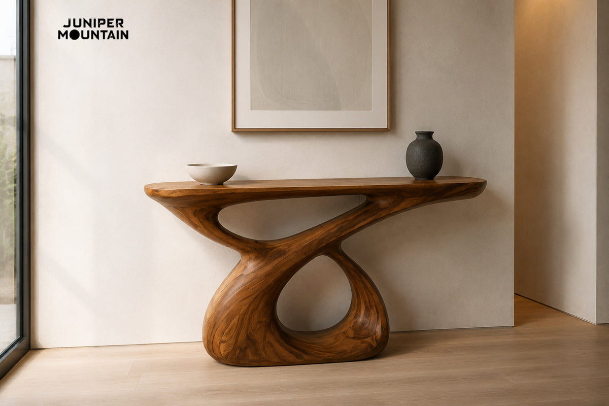 Brown loop-base console table with an ivory bowl and charcoal vase against a pale entryway wall; generated styling illustration.
