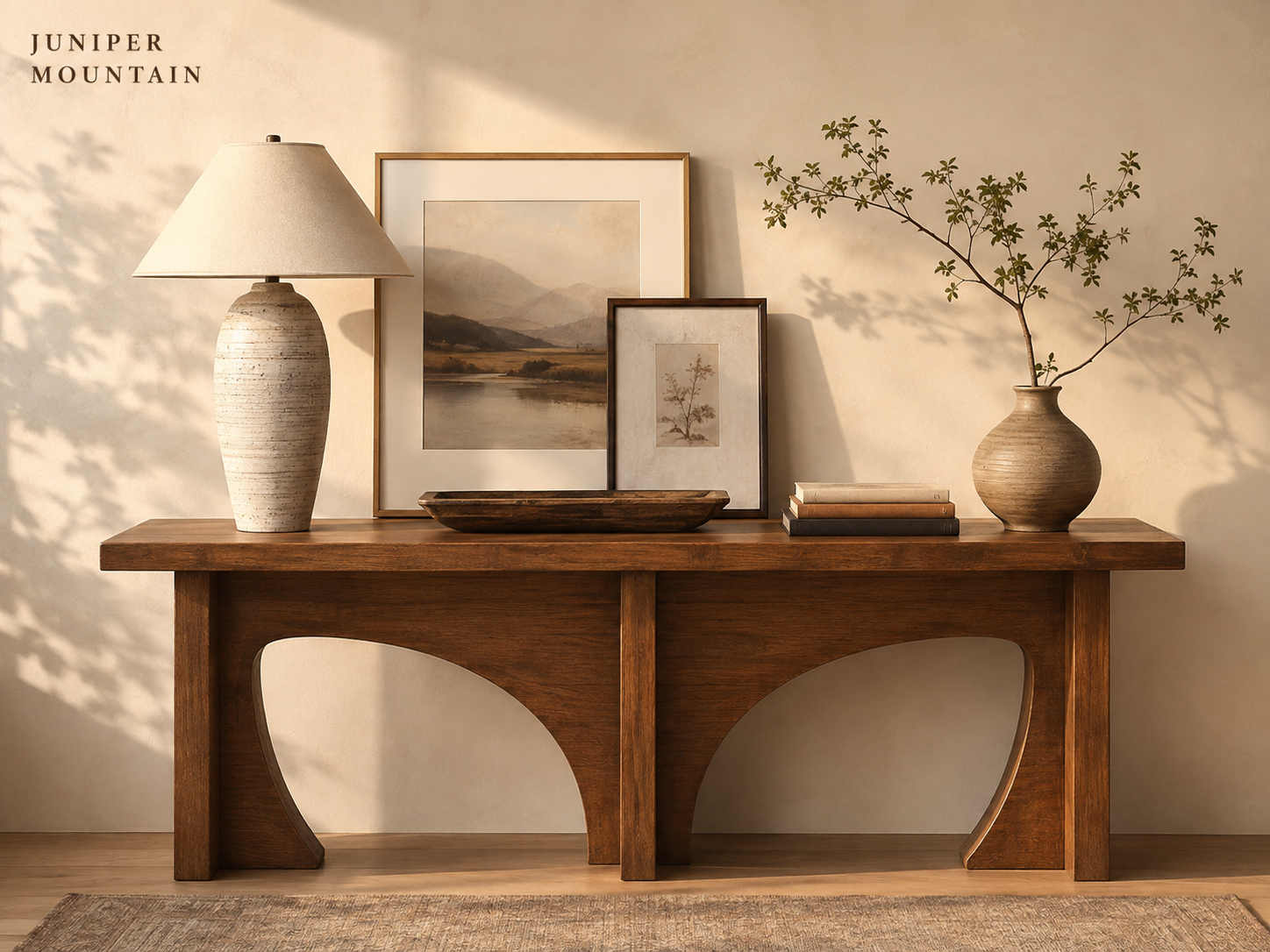 Console table styled with lamp artwork books tray and branches
