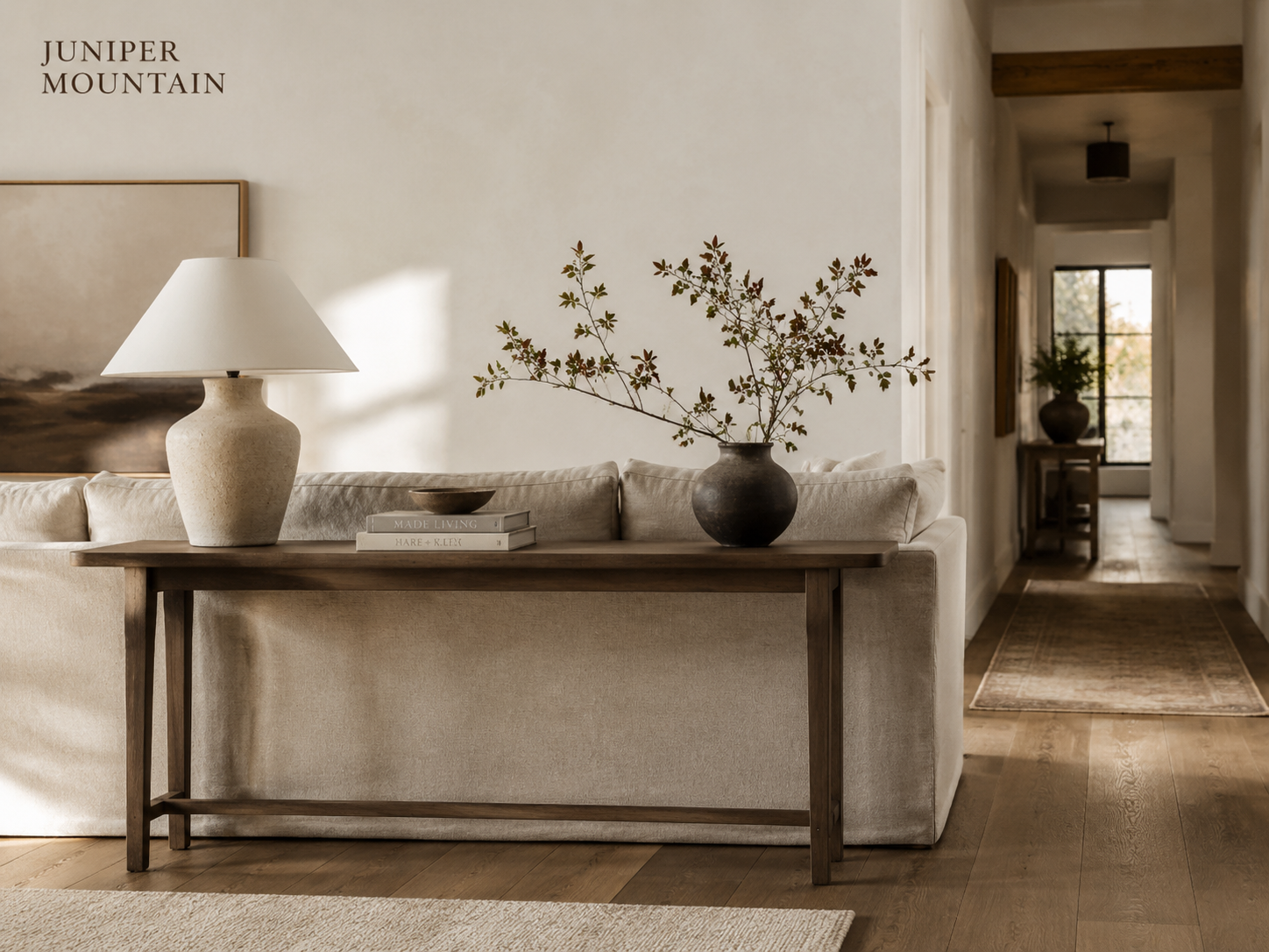 Slim wood console used behind a sofa in a warm living room